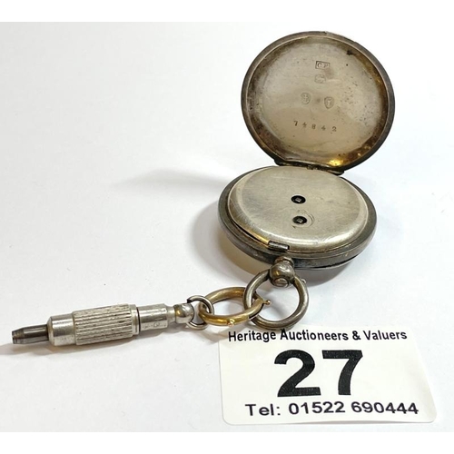 An antique silver open face pocket watch with key
