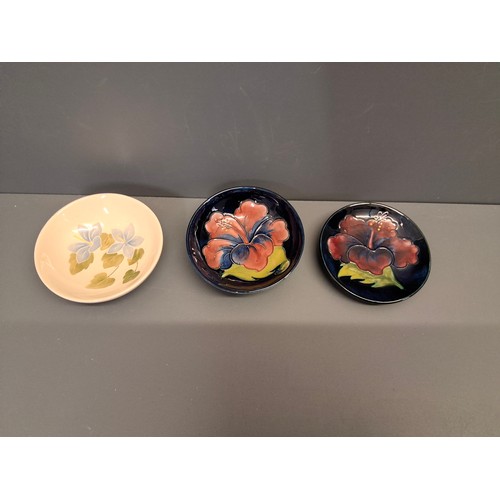 42 - Three Moorcroft Pin Dishes. Two in the hibiscus pattern and the other in the campanula pattern.
