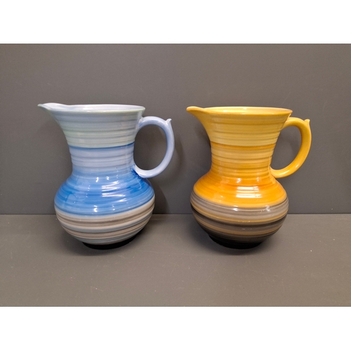 46 - Two Shelly brightly coloured jugs with ribbed pattern all around the jugs.
Each jug is 19cm in Heigh... 