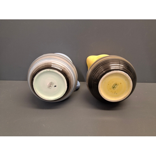 46 - Two Shelly brightly coloured jugs with ribbed pattern all around the jugs.
Each jug is 19cm in Heigh... 