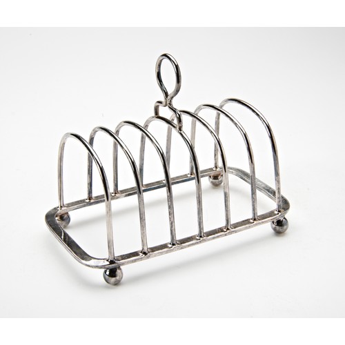 215 - SILVER TOAST RACK SHEFFIELD 1946 raised on ball feet 12cm wide 3.7 oz117 grams... 