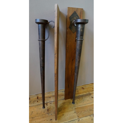 32 - A PAIR OF LARGE WALL MOUNTED TAPERED CYLINDRICAL METAL CANDLE HOLDERS, with serpentine brackets moun... 