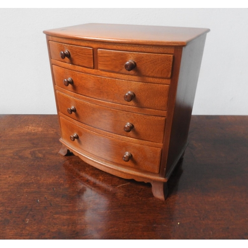 61 - MINIATURE TABLE TOP BOW-FRONT HARDWOOD CHEST OF FIVE DRAWERS