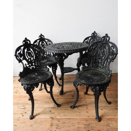 16 - A HEAVY CAST-IRON ORNATE PIERCED PATIO TABLE AND FOUR MATCHING CHAIRS, the table with 'jubilee' deco... 