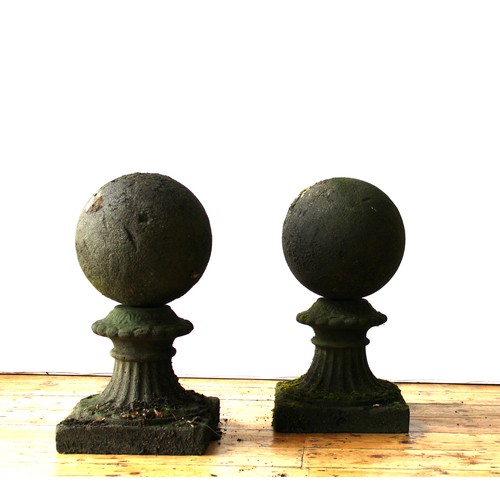 101 - A PAIR OF WEATHERED SPHERICAL SHAPED GARDEN FINIAL PILLAR TOPS ON TAPERED PLINTHS, 65cm high