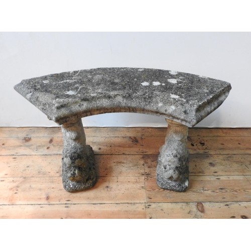 111 - A WEATHERED CURVED SEATED RECONSTITUTED STONE GARDEN BENCH, the two supports with carved fish decora... 