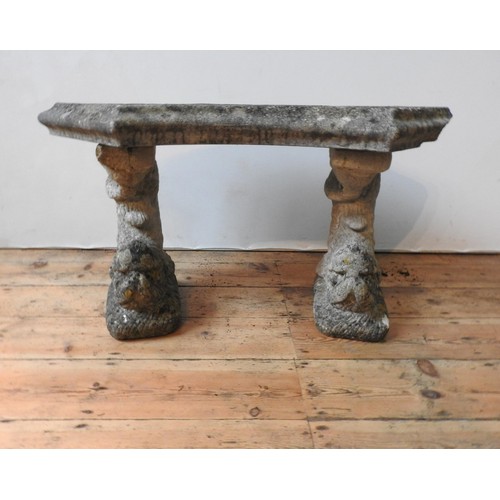 111 - A WEATHERED CURVED SEATED RECONSTITUTED STONE GARDEN BENCH, the two supports with carved fish decora... 