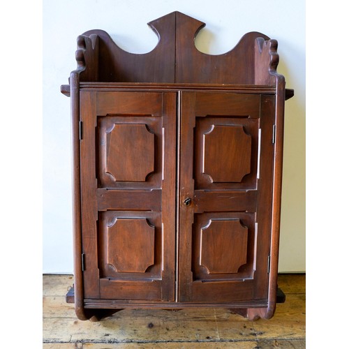 68 - AN ARTS AND CRAFTS WALL MOUNTED CABINET, with panelled doors and fitted shelf, 85 x 53cms