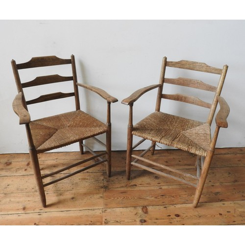 71 - A PAIR OF RUSTIC OAK LADDERBACK RUSH SEAT CHAIRS