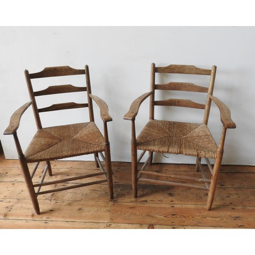 71 - A PAIR OF RUSTIC OAK LADDERBACK RUSH SEAT CHAIRS