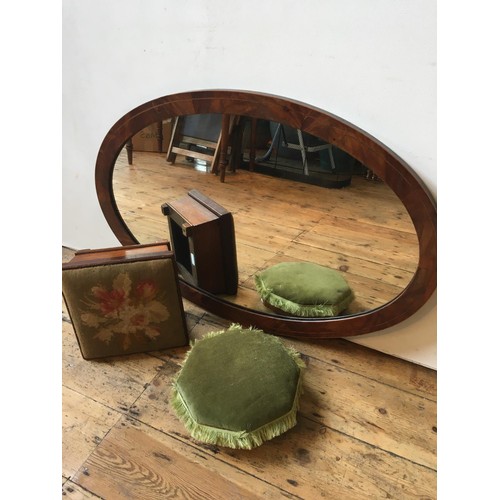 25 - A MAHOGANY OVAL FRAMED WALL MIRROR AND TWO VICTORIAN UPHOLSTERED FOOT STOOLS, the mirror 97 x 60cms