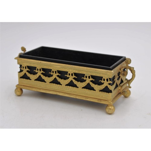 261 - AN EBONY OBLONG BOX IN AN ORNATE GILDED METAL STAND, the stand with swag decoration, two foliate han... 