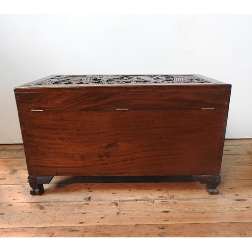 34 - AN ORNATE CARVED CAMPHORWOOD BLANKET CHEST , with two carved handles and claw feet,  62 x 98 x 54 cm