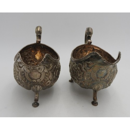 318 - A PAIR OF IRISH HALLMARK SILVER SAUCEBOATS, with ornate floral embossed decoration with ornate scrol... 