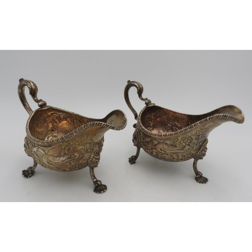 319 - A PAIR OF LARGE IRISH HALLMARK SILVER SAUCEBOATS, with extensive foliate and bird embossed decoratio... 