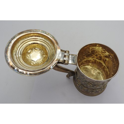 320 - A GEORGE III HALLMARK SILVER TANKARD WITH LID, 1763 with extensive floriform embossed decoration thr... 