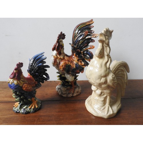 278 - THREE 20TH CENTURY GLAZED COCKEREL ORNAMENTS, two painted and one cream glazed, the largest 48 cm hi... 