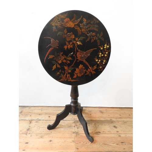 66 - A VICTORIAN JAPANNED TILT TOP TRIPOD TABLE, 75 cm high x 57 cm dia, with foliate and bird painted de... 