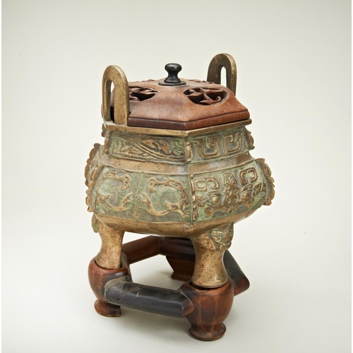 15 - ARCHAICISTIC BRONZE TRIPOD CENSER QING DYNATY, 19TH CENTURYwith a fitted hardwood stand and cover, t... 