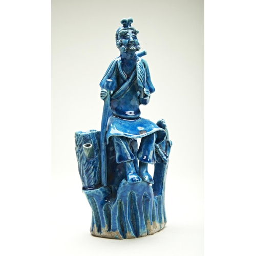 53 - TURQUOISE-GLAZED POTTERY FIGURE KANGXI PERIOD (1662-1722)modelled seated on a bamboo stump with a mo... 