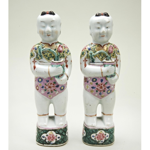 96 - PAIR OF FAMILLE ROSE BOYSQING DYNASTY, 18TH CENTURYstanding on square platforms painted with scrolli... 