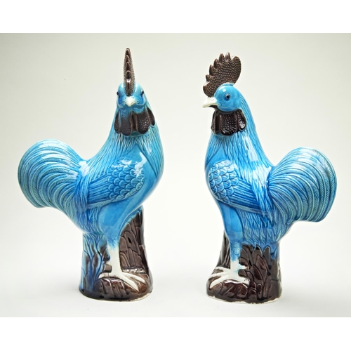 59 - PAIR OF TURQUOISE-GLAZED COCKERELS LATE QING DYNASTYeach standing astride a tree stump with heads tu... 