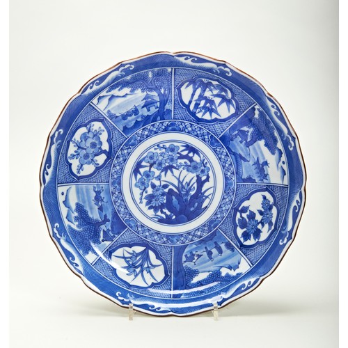 292 - JAPANESE BLUE AND WHITE BARBED DISH MEIJI PERIOD (1868-1912)painted with panels of landscape views a... 