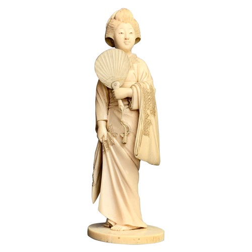 325 - JAPANESE IVORY OKIMONO OF A GEISHA, MEIJI PERIODthe geisha holding a fan, her other hand lifting her... 