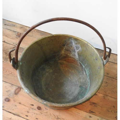 95 - A CONTINENTAL RIVETED BRASS BUCKET WITH IRON RING HANDLE, 52cm dia