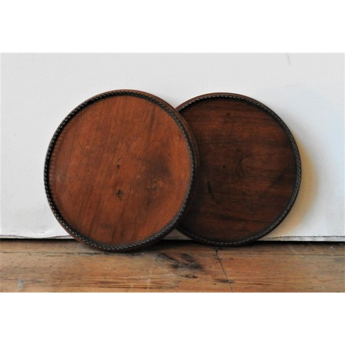 27 - A PAIR OF 19TH CENTURY MAHOGANY CIRCULAR TRAYS, with gallery edge, 26 cm dia