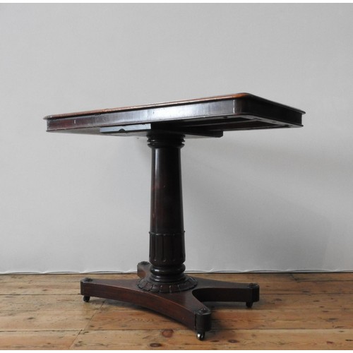 61 - A VICTORIAN MAHOGANY TABLE WITH TWO WRITING SLOPE SECTIONS, on a tulip carved pedestal with an X-sha... 