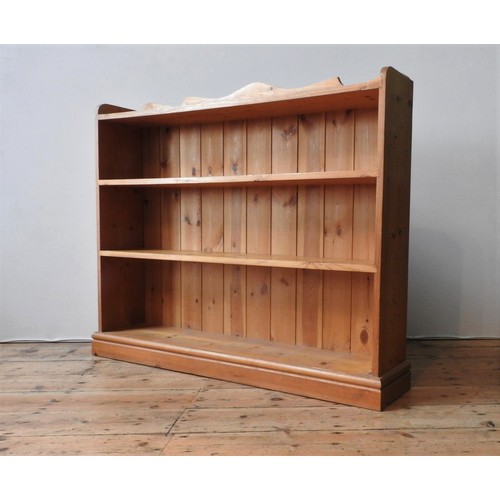 62 - A PINE FOUR TIER BOOKSHELF, with serpentine gallery back, 103 x 122 x 24 cm