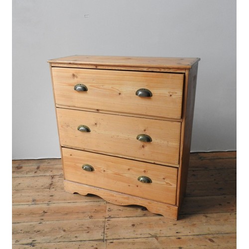 66 - A WAXED PINE CHEST OF THREE DRAWERS, the three drawers with brass cup handles set in a useful sized ... 