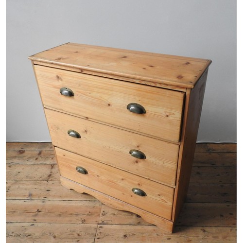 66 - A WAXED PINE CHEST OF THREE DRAWERS, the three drawers with brass cup handles set in a useful sized ... 