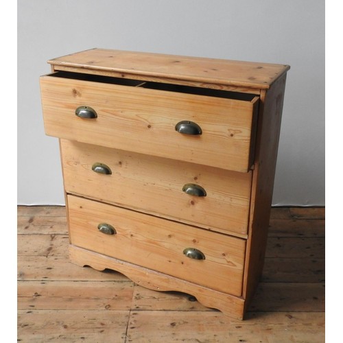 66 - A WAXED PINE CHEST OF THREE DRAWERS, the three drawers with brass cup handles set in a useful sized ... 