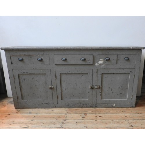 76 - A RUSTIC DISTESSED PAINTED THREE DOOR PINE DRESSER BASE, with three drawers fitted with brass cup ha... 