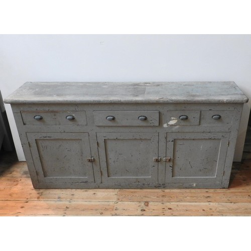 76 - A RUSTIC DISTESSED PAINTED THREE DOOR PINE DRESSER BASE, with three drawers fitted with brass cup ha... 