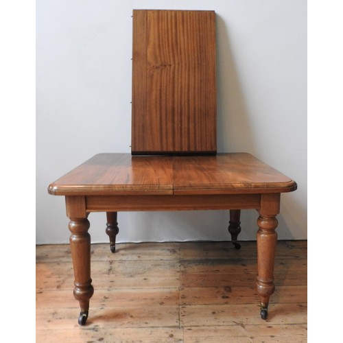 79 - AN EDWARDIAN MAHOGANY WIND-OUT EXTENDING DINING TABLE, with extra leaf insertion, on turned legs ter... 