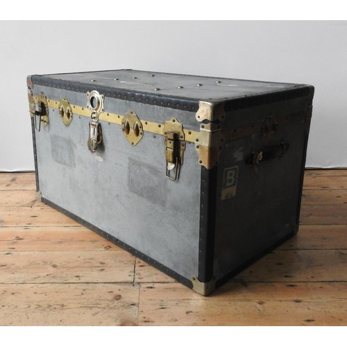 84 - A TIN COVERED VINTAGE TRAVEL TRUNK, with two handles, latches and vintage air travel labels attached... 