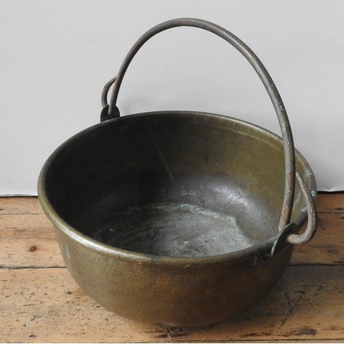 107 - A 19TH CENTURY HAMMERED BRASS BUCKET WITH IRON RING HANDLE, 48.5 cm diameter