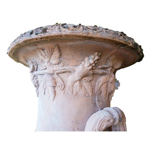 96 - LARGE GARDEN STONEWARE URN20TH CENTURYof campana form, with Bacchic relief decoration, raised on a s... 