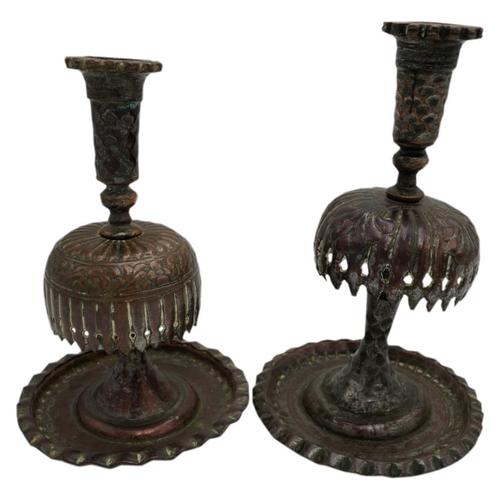 379 - TWO PERSIAN TINNED COPPER CANDLESTICKS19TH CENTURY raised on a wide dished circular foot19cm & 2... 