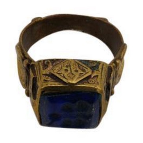 387 - A PERSIAN/BYZANTINE POLISHED BRONZE RING, the raised square top inset with a lapis stone engraved wi... 