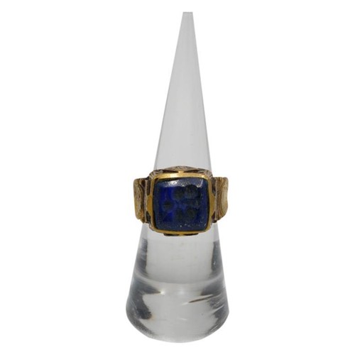 387 - A PERSIAN/BYZANTINE POLISHED BRONZE RING, the raised square top inset with a lapis stone engraved wi... 