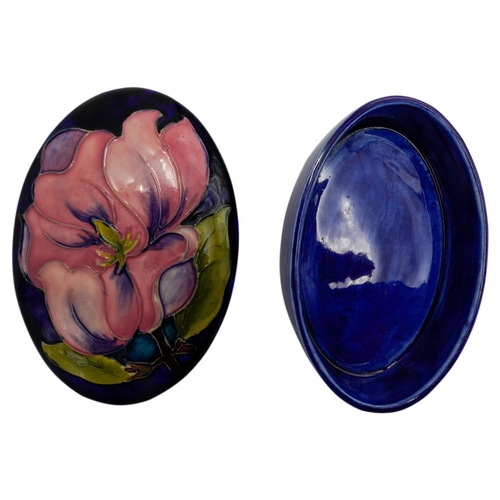 224 - TWO MOORCROFT MAGNOLIA PATTERN BOXESeach decorated with blossoming magnolias on a blue ground, impre... 