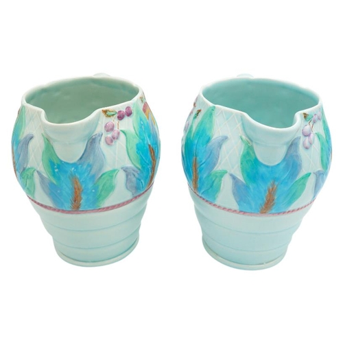 189 - TWO CLARICE CLIFF NEWPORT POTTERY MOULDED JUGSdecorated with a band of leaves and fruit, green print... 