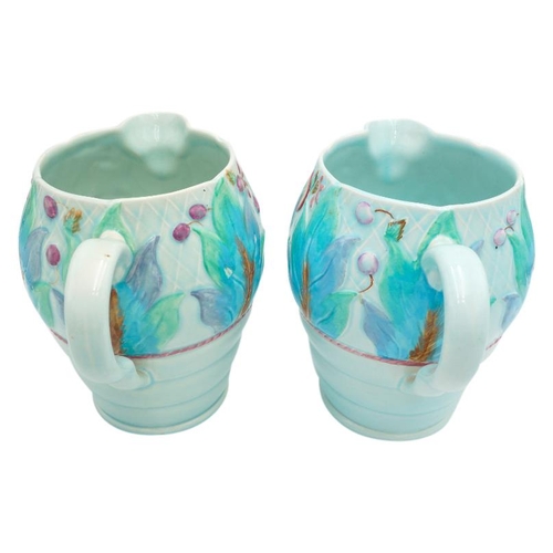 189 - TWO CLARICE CLIFF NEWPORT POTTERY MOULDED JUGSdecorated with a band of leaves and fruit, green print... 