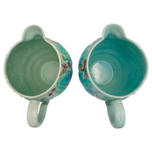 189 - TWO CLARICE CLIFF NEWPORT POTTERY MOULDED JUGSdecorated with a band of leaves and fruit, green print... 