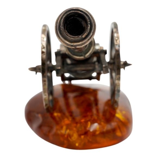 493 - SILVERED-METAL MINIATURE CANNON ON AN AMBER BASE20TH CENTURY10cm long approx.PROVENANCE : Private Ox... 