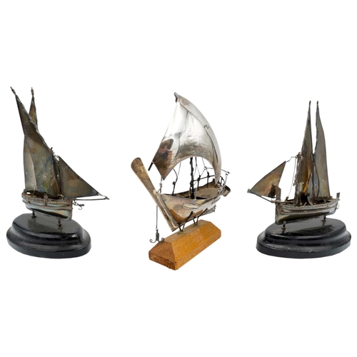 503 - THREE MINIATURE SILVERED-METAL MODEL SAILING BOATS20TH CENTURYraised on wooden bases. 14cm long appr... 